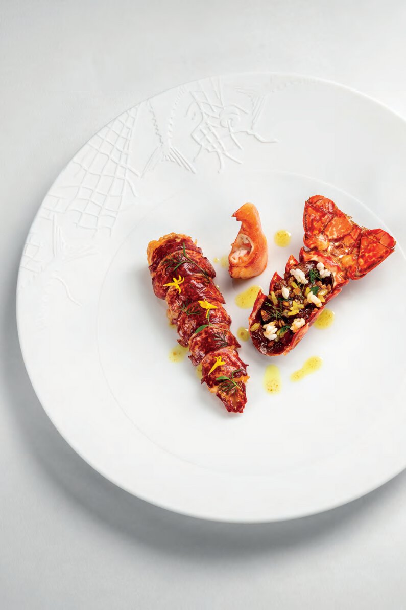 Homard bleu cuit au charbon bois et laqué au jus de viande, confit d’oignons, tomates aux 10 épices et épeautre soufflé