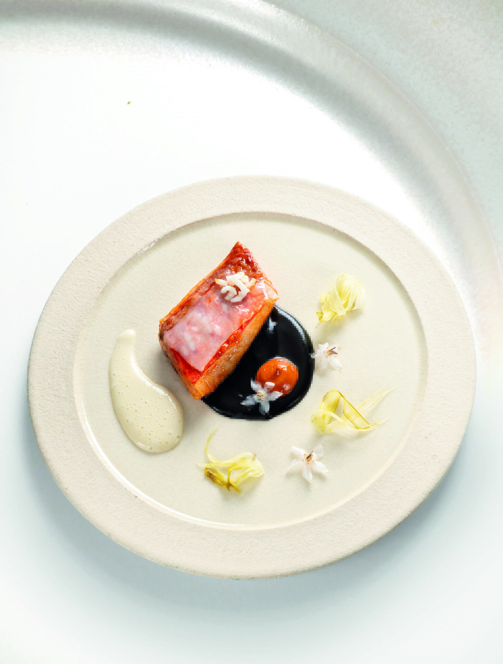 Rouget-barbet cuit au beurre de foie, sauce seiche, lard à l’ail noir et jus de moules
