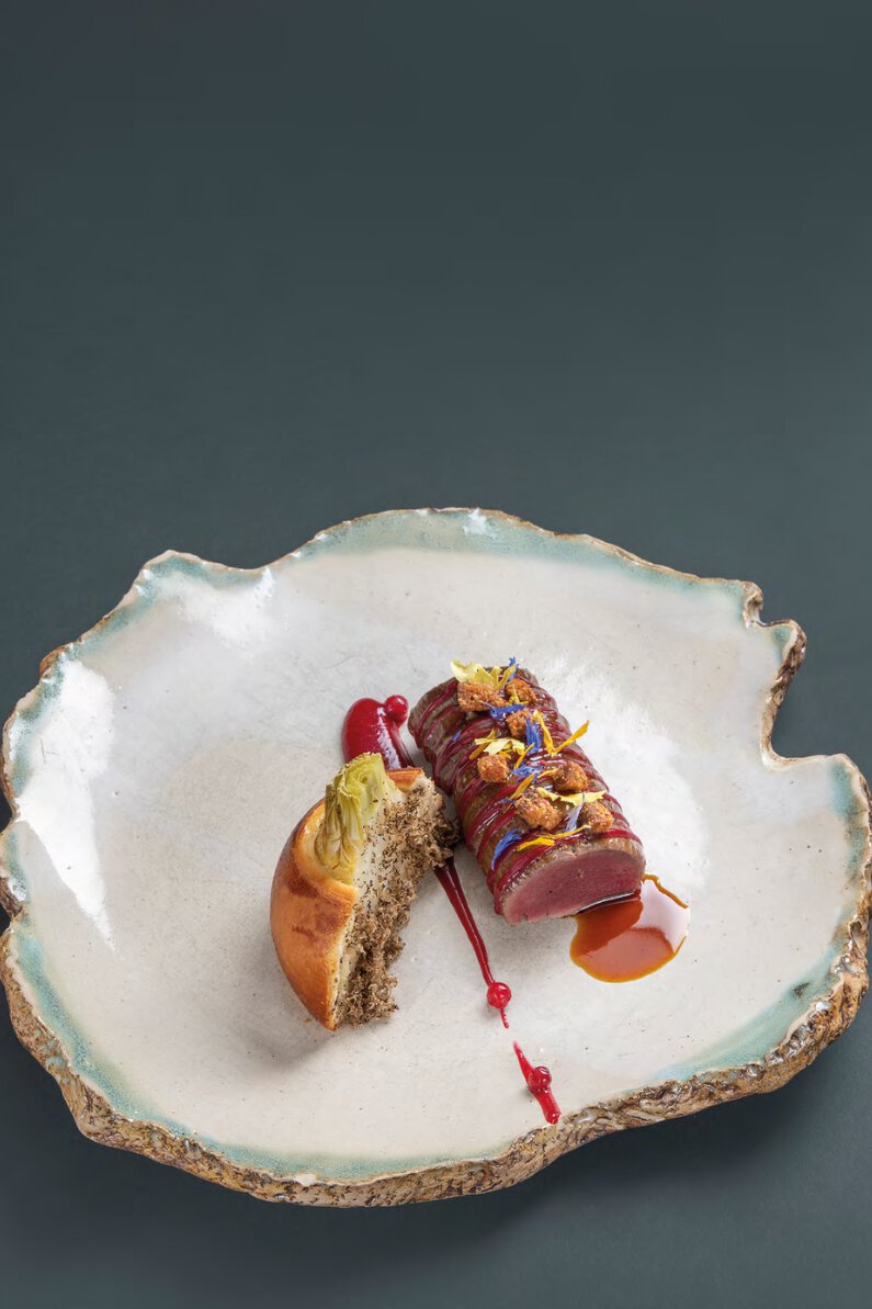 Chevreuil de chasse française rôti, pétales de fleurs séchées, gel d’airelles, céleri en brioche, jus réduit