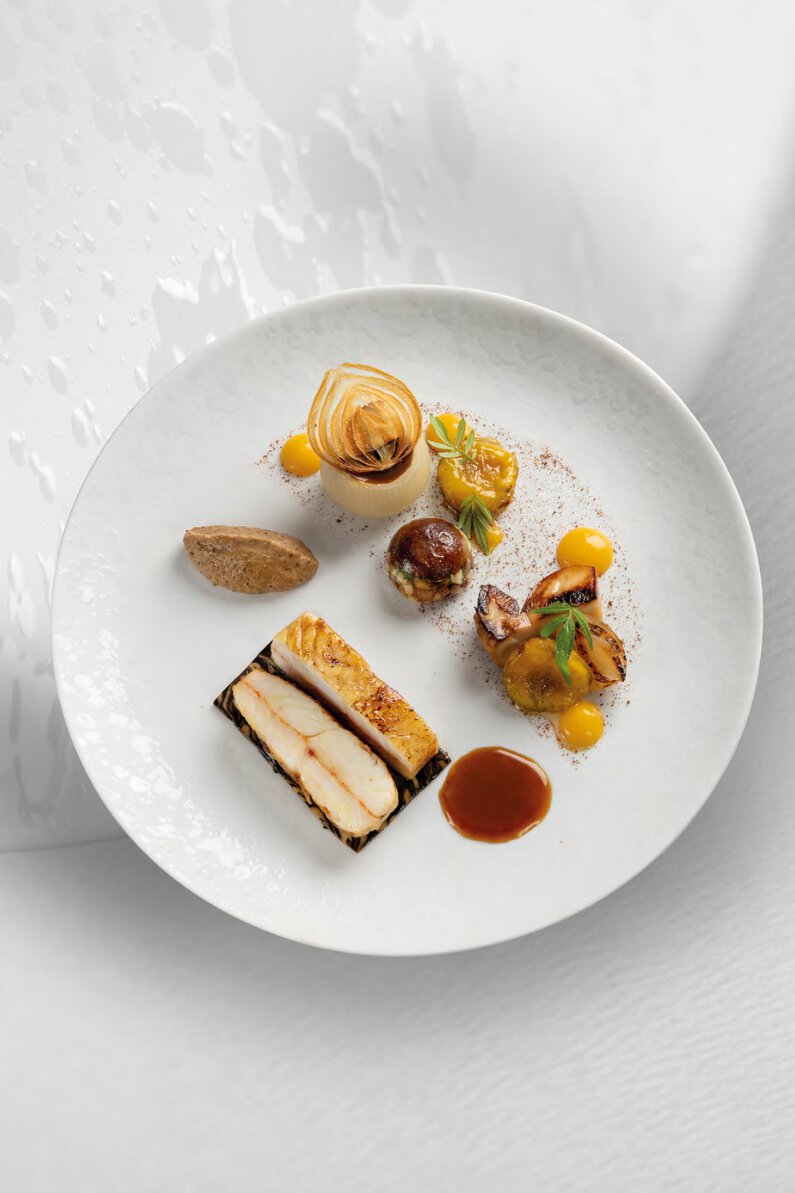 Le pavé de turbot rôti meunière, cèpes poêlés en déclinaison, condiment de prune, oignons des cévennes confits, jus d’oignons grillés au vinaigre de prune