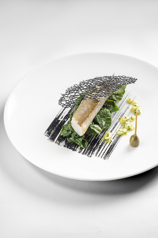 Cabillaud skrei juste cuit, tuile à l’encre de seiche, jeunes pousses d’épinards en vinaigrette d’encornet et câpre à queue