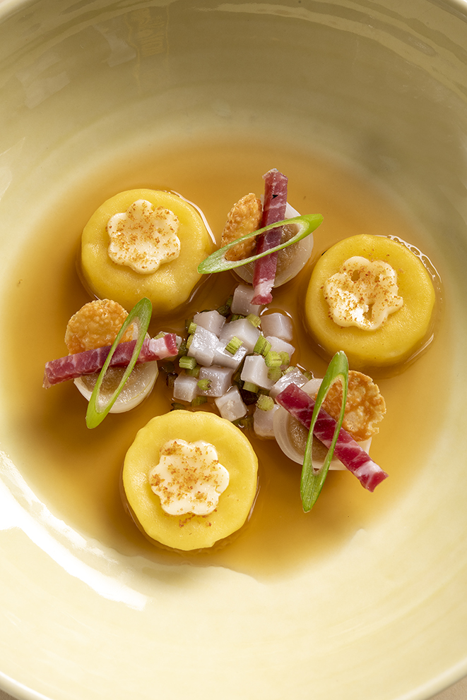 Abbaye de tamié en raviole, court-bouillon de jambon cru, culatello, rouelles d’oignons frits, berce ciselée
