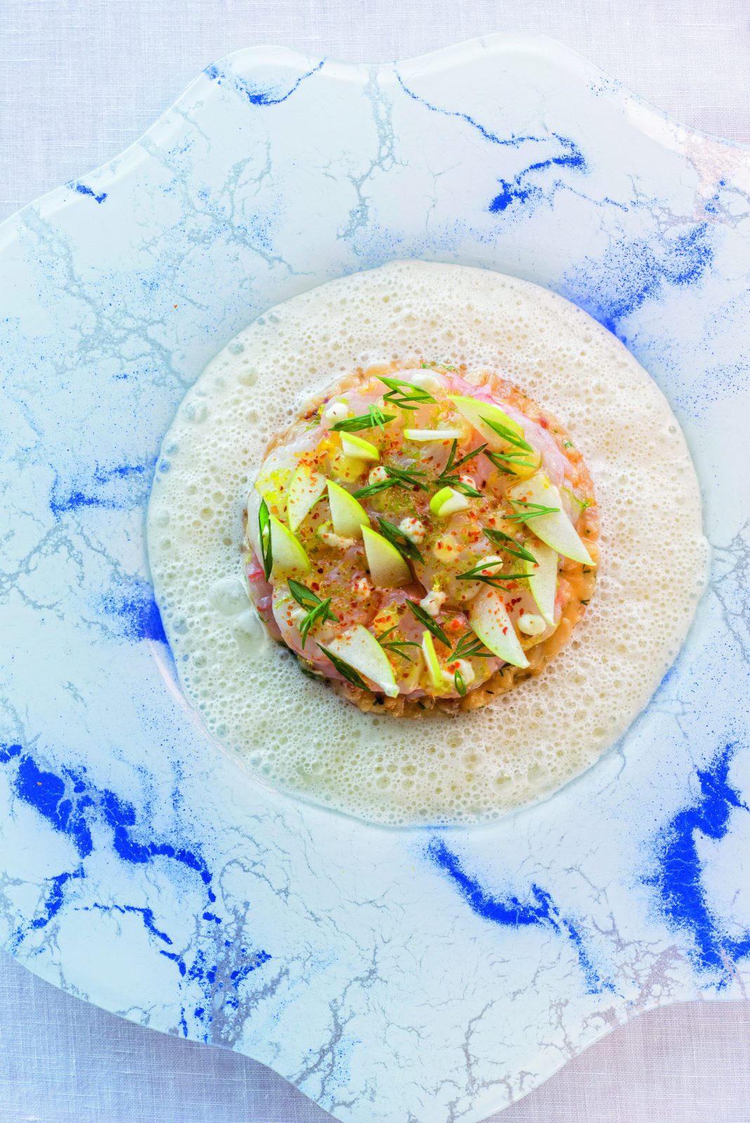 Risotto cuisiné à l’anguille fumée, langoustines en épais carpaccio, émulsion au parmesan